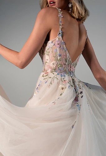 Bride wearing tulle wedding dress with pastel floral appliques finished with a sheer back and zipper closure, Stella York 8063