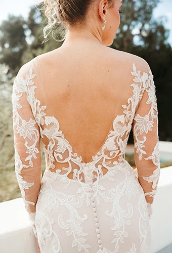Bride wearing fit-and-flare wedding dress with illusion lace back and long sleeves, Stella York SY8162