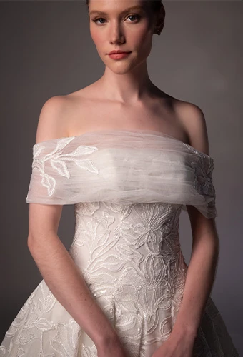 Bride wearing lace wedding gown with off the shoulder straps