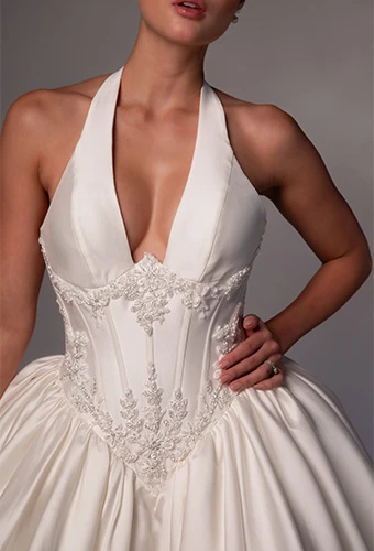 Bride wearing ballgown wedding dress with plunging neckline and beaded details