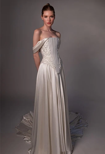 Bride wearing silk wedding gown with off the shoulder straps and corset bodice