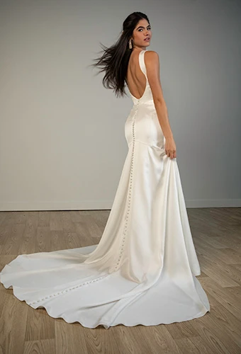 Bride wearing satin fit-and-flare wedding dress with low back leading to flowing train, Stella York SY8338