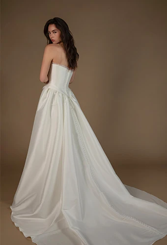 Bride wearing strapless a line wedding gown with fabric covered buttons