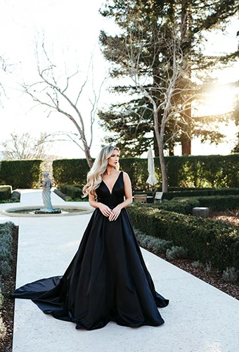 Bride wearing simple A-line black wedding dress with thick straps and deep V-neckline, Stella York SY7755BLK