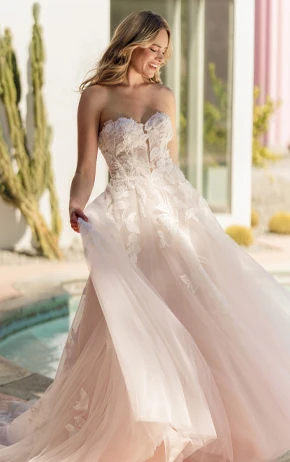 Ballgown wedding dress by Stella York, style SY8166. Features a strapless sweetheart neckline, lace bodice, and voluminous tulle skirt. Photographed outdoors with a natural background.
