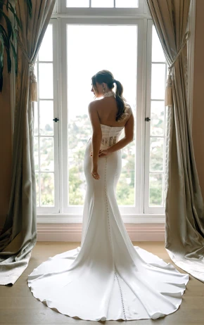 Stella York SY8248 fit-and-flare wedding gown with a strapless sweetheart neckline, lace bodice, and voluminous tulle skirt. Model stands in front of a window