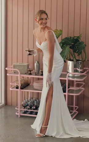 Bride wearing Stella York style SY8224 standing in front of a shelf with plants.