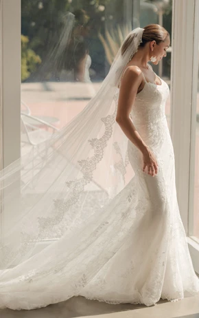 A bride wearing Stella York trending Style SY8237 standing in front of a window.
