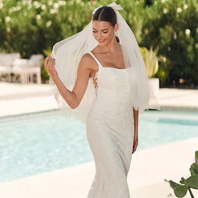 Bride wearing lace scoop neck wedding dress with side cutouts