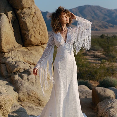 bride wearing boho fit-and-flare lace wedding dress with plunging neckline