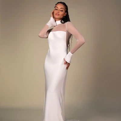 Bride wearing crepe column wedding dress with sleeves and high-neck