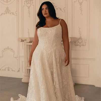 Bride wearing plus size lace a-line wedding dress with spaghetti straps