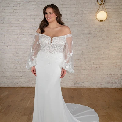 Bride wearing plus size boho long sleeve wedding dress with plunging neck