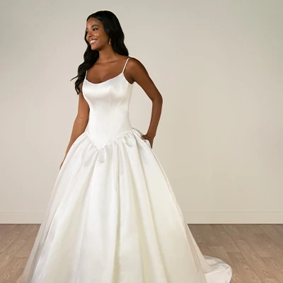 Bride wearing scoop neckline satin ballgown with basque waist and pockets